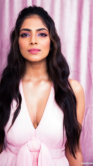 Malavika Mohanan in a soft pink dress with long wavy hair and purple eye makeup HD phone wallpaper