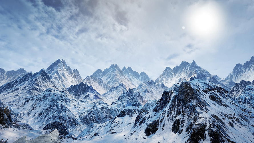 Majestic Snow-Capped Mountain Range Under a Bright Winter Sky HD wallpaper