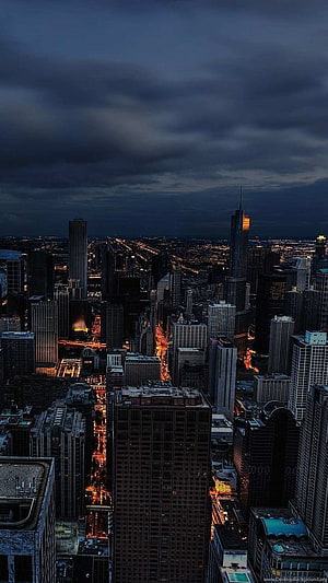 Dramatic Twilight Skyline of a Dense Urban Metropolis with Glowing Street Lights HD phone wallpaper