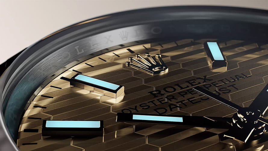 Close-up of a gold Rolex Oyster Perpetual Datejust watch face with luminous hour markers HD wallpaper