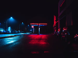 Moody Nighttime Gas Station Scene with Neon Red and Blue Lighting HD wallpaper