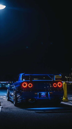 Blue Nissan Skyline GT-R R34 Rear View at Night with Glowing LED Taillights HD phone wallpaper