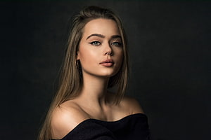 Elegant Portrait of a Woman with Long Blonde Hair and Green Eyes in Dark Studio Setting HD wallpaper