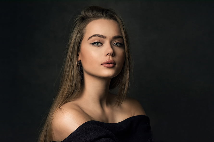 Elegant Portrait of a Woman with Long Blonde Hair and Green Eyes in Dark Studio Setting HD wallpaper