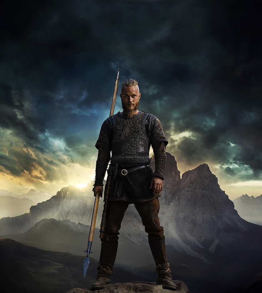 Ragnar Lothbrok from Vikings Standing on a Rocky Peak with a Spear Under a Dramatic Sky HD phone wallpaper