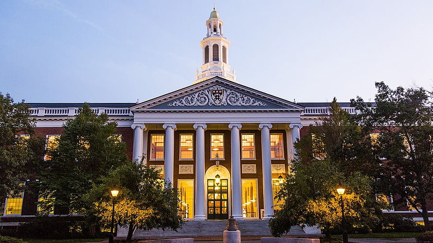 Harvard Business School Main Building at Dusk with Illuminated Windows and Classical Columns HD wallpaper