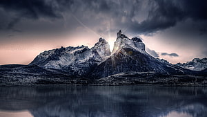 Dramatic Snow-Capped Mountain Peaks Reflected in a Calm Lake at Sunrise HD wallpaper