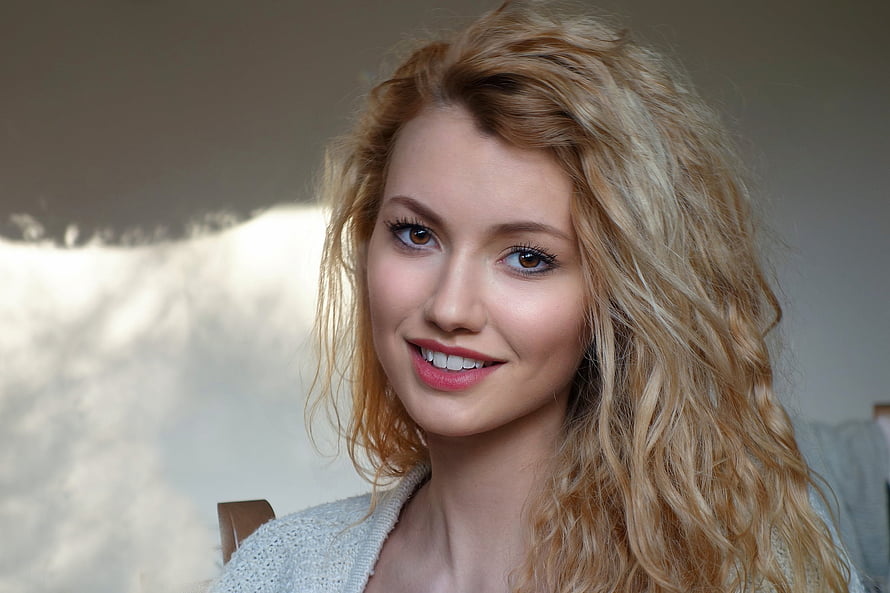 Portrait of a smiling woman with long wavy blonde hair and soft natural makeup HD wallpaper