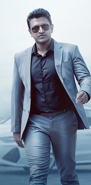 Puneeth Rajkumar in a grey suit and black shirt with aviator sunglasses HD phone wallpaper