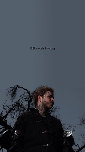 Post Malone in Dark Tactical Gear Against a Bleak Sky HD phone wallpaper
