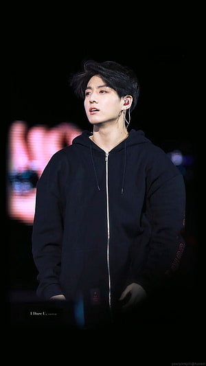 Jungkook from BTS in a black zip-up hoodie on stage with concert lighting HD phone wallpaper