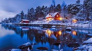 Cozy Red Lakeside Cabin in Snowy Winter Twilight with Warm Light Reflections HD wallpaper