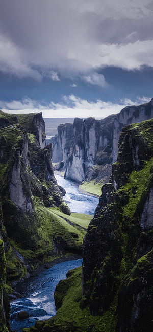 Dramatic Iceland Canyon with Mossy Cliffs and Winding River Under Stormy Skies HD phone wallpaper