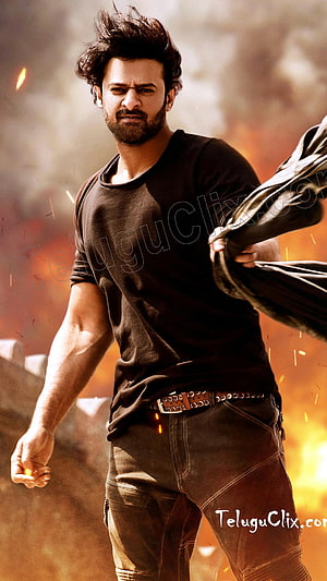Prabhas Intense Action Pose Amidst Fire and Smoke in Dark Attire HD phone wallpaper