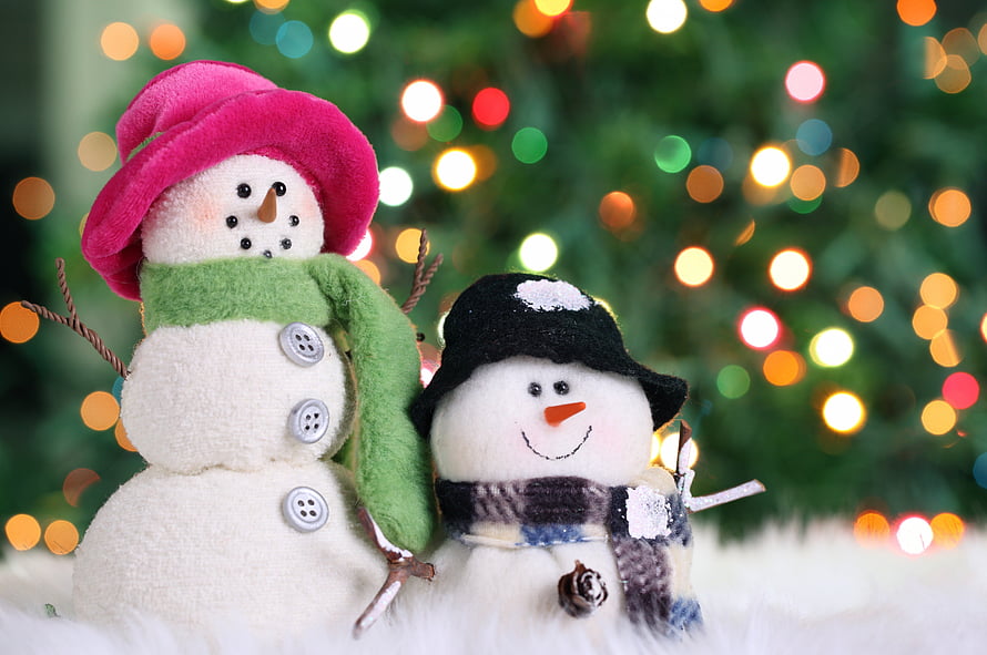 Cute Felt Snowman Couple with Hats and Scarves Against Festive Christmas Tree Bokeh HD wallpaper