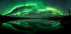 Vivid Green Aurora Borealis Reflecting on a Calm Lake in Alaska HD wallpaper