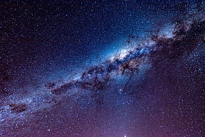Milky Way Galaxy Spanning a Deep Blue and Purple Starry Night Sky HD wallpaper