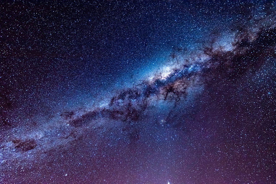 Milky Way Galaxy Spanning a Deep Blue and Purple Starry Night Sky HD wallpaper