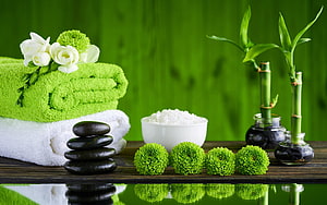 Serene Spa Still Life With Green Towels, Black Stones, Bamboo, and Fresh Flowers HD wallpaper