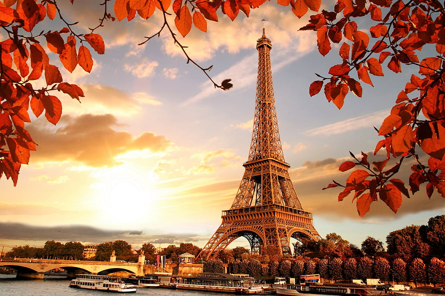 Eiffel Tower in Paris framed by autumn leaves at golden hour sunset HD wallpaper