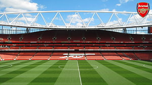 Emirates Stadium Interior View With Arsenal Crest And Red Seating HD wallpaper