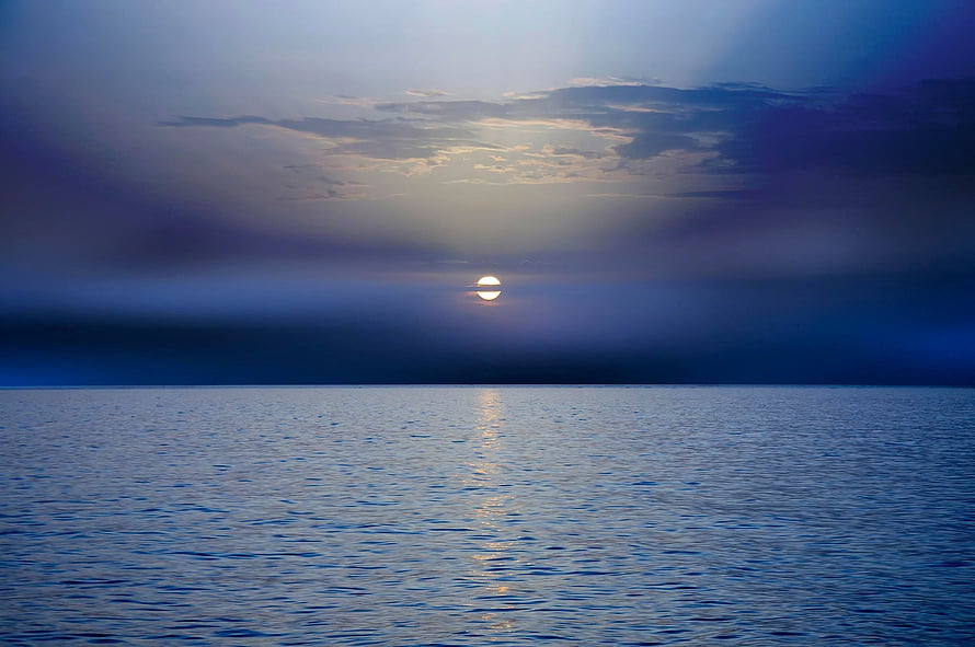 Serene Ocean Sunset with Sun Reflecting on Calm Water and Dark Clouds HD wallpaper