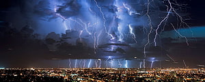 Dramatic Night Lightning Storm Over a Glowing City Skyline HD wallpaper