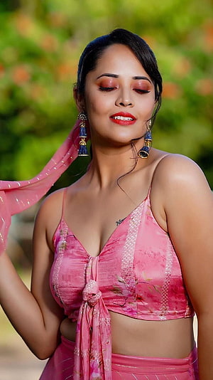 Anusuya Bharadwaj in a pink floral lehenga with traditional jhumka earrings and soft garden backdrop HD phone wallpaper