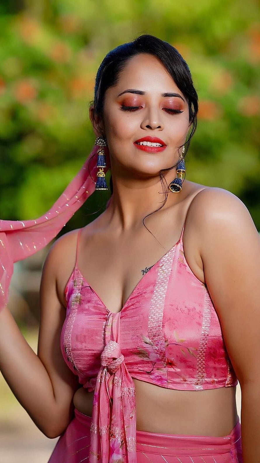 Anusuya Bharadwaj in a pink floral lehenga with traditional jhumka earrings and soft garden backdrop HD phone wallpaper