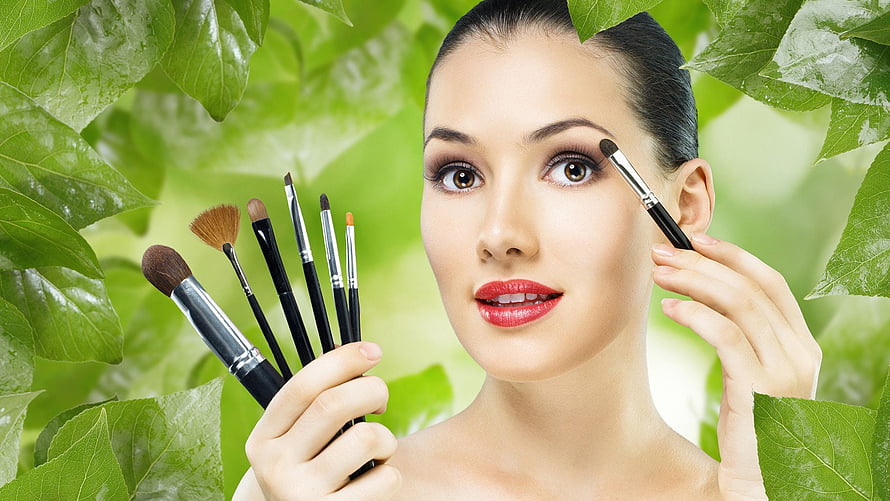 Woman Applying Makeup With Brushes Surrounded By Fresh Green Leaves, Beauty Salon - Beauty Parlour HD wallpaper