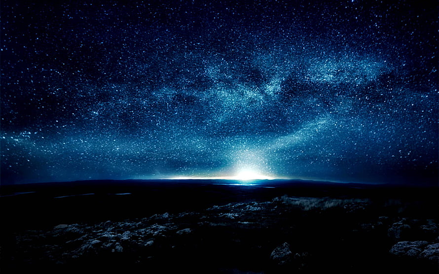 Milky Way Galaxy Arching Over a Dark Rocky Landscape at Night HD wallpaper