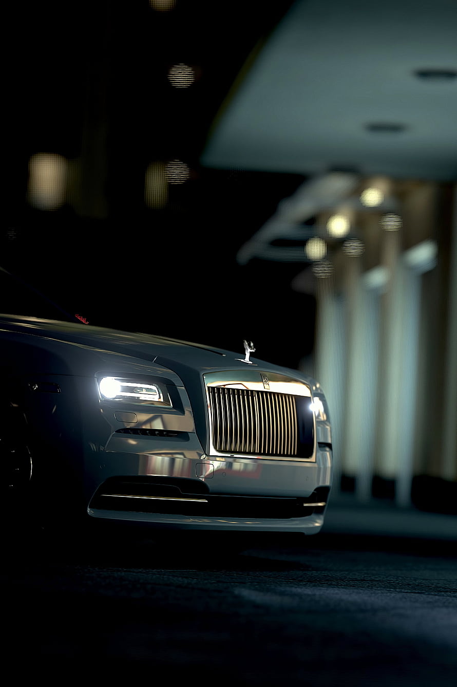 Rolls-Royce Front Grille and Headlights Illuminated at Night in a Luxury Setting HD phone wallpaper