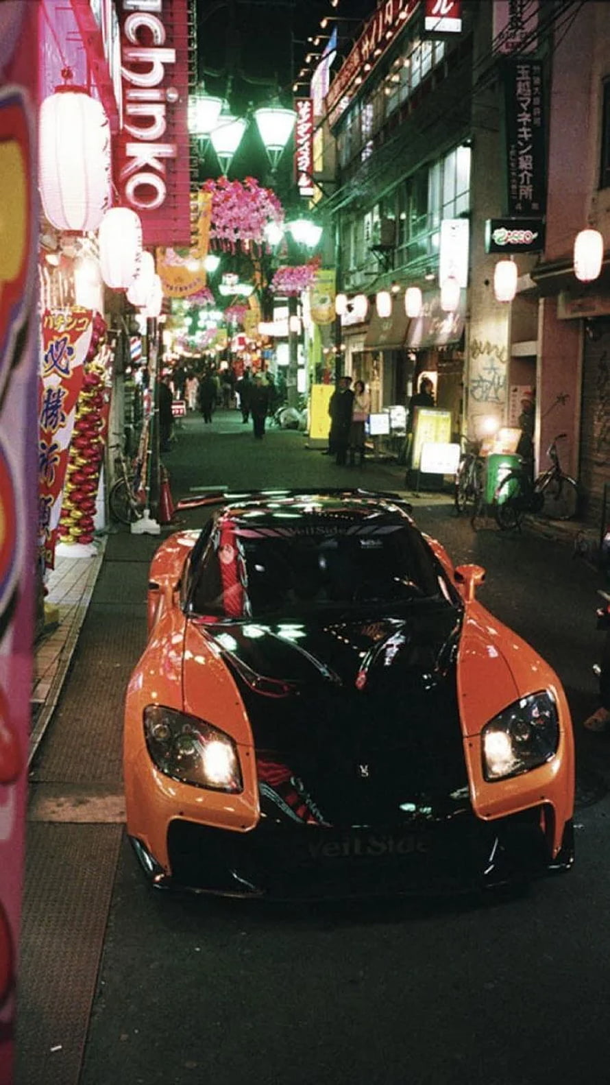 Orange Nissan GT-R R35 parked on a neon-lit Tokyo street at night HD phone wallpaper