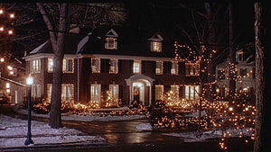 Home Alone Christmas House Exterior with Warm String Lights and Snowy Night Scene HD wallpaper
