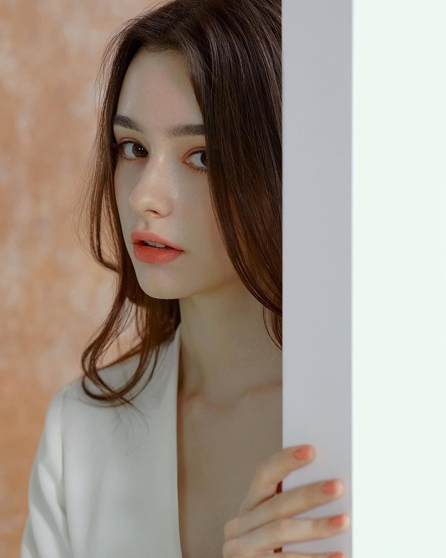 Dasha Taran Portrait Peeking From Behind a White Wall HD phone wallpaper