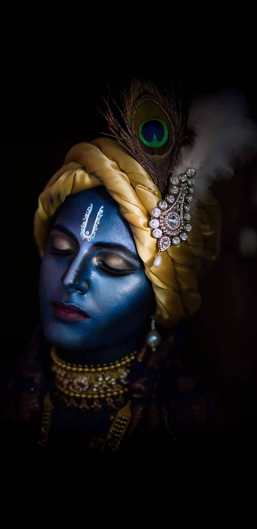 Krishna Portrait with Blue Face, Golden Turban, and Peacock Feather in Dramatic Low-Key Lighting HD phone wallpaper