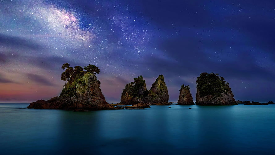 Milky Way Galaxy Arches Over Coastal Sea Stacks and Rocky Islands at Night HD wallpaper