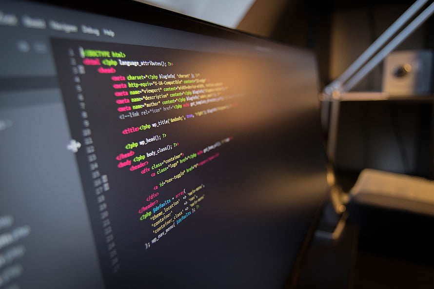 Close-up of PHP and HTML code on a dark monitor screen in a dimly lit workspace HD wallpaper