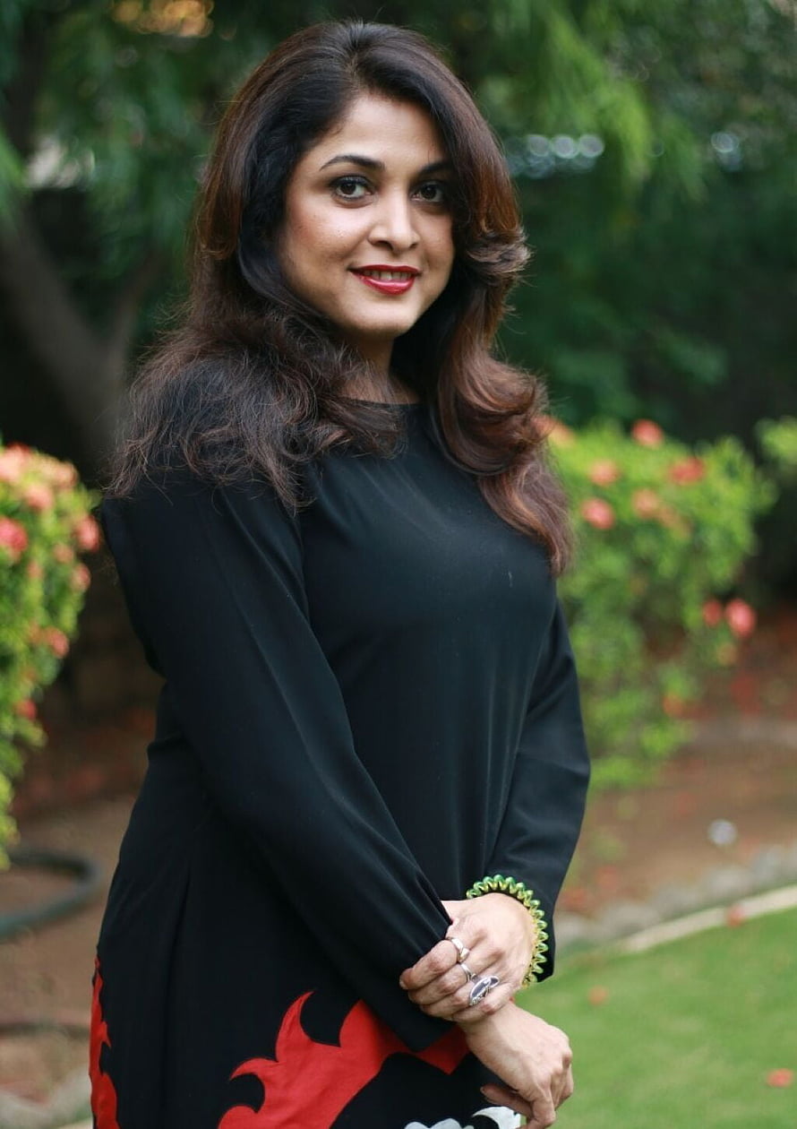 Ramya Krishnan in Black Kurta with Red Floral Pattern in Garden Setting HD phone wallpaper