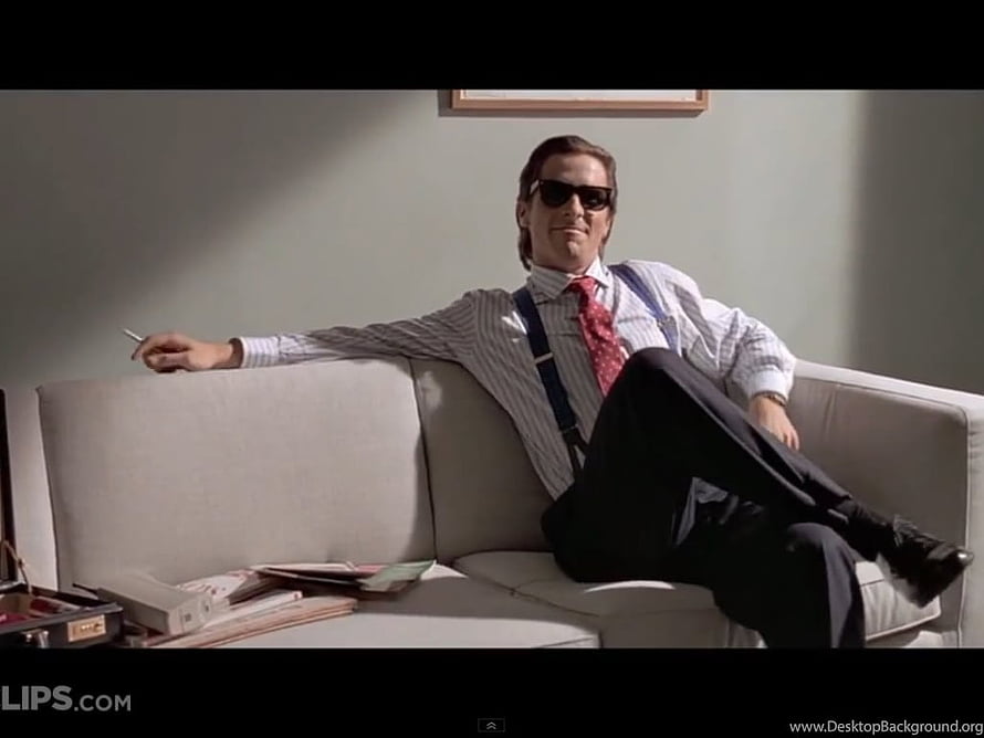 Patrick Bateman from American Psycho relaxing on a white sofa in a minimalist office HD wallpaper