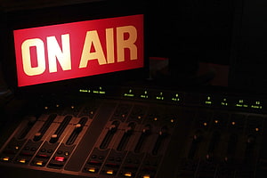 Illuminated On Air Sign Above Professional Audio Mixing Console in Dark Broadcast Studio HD wallpaper