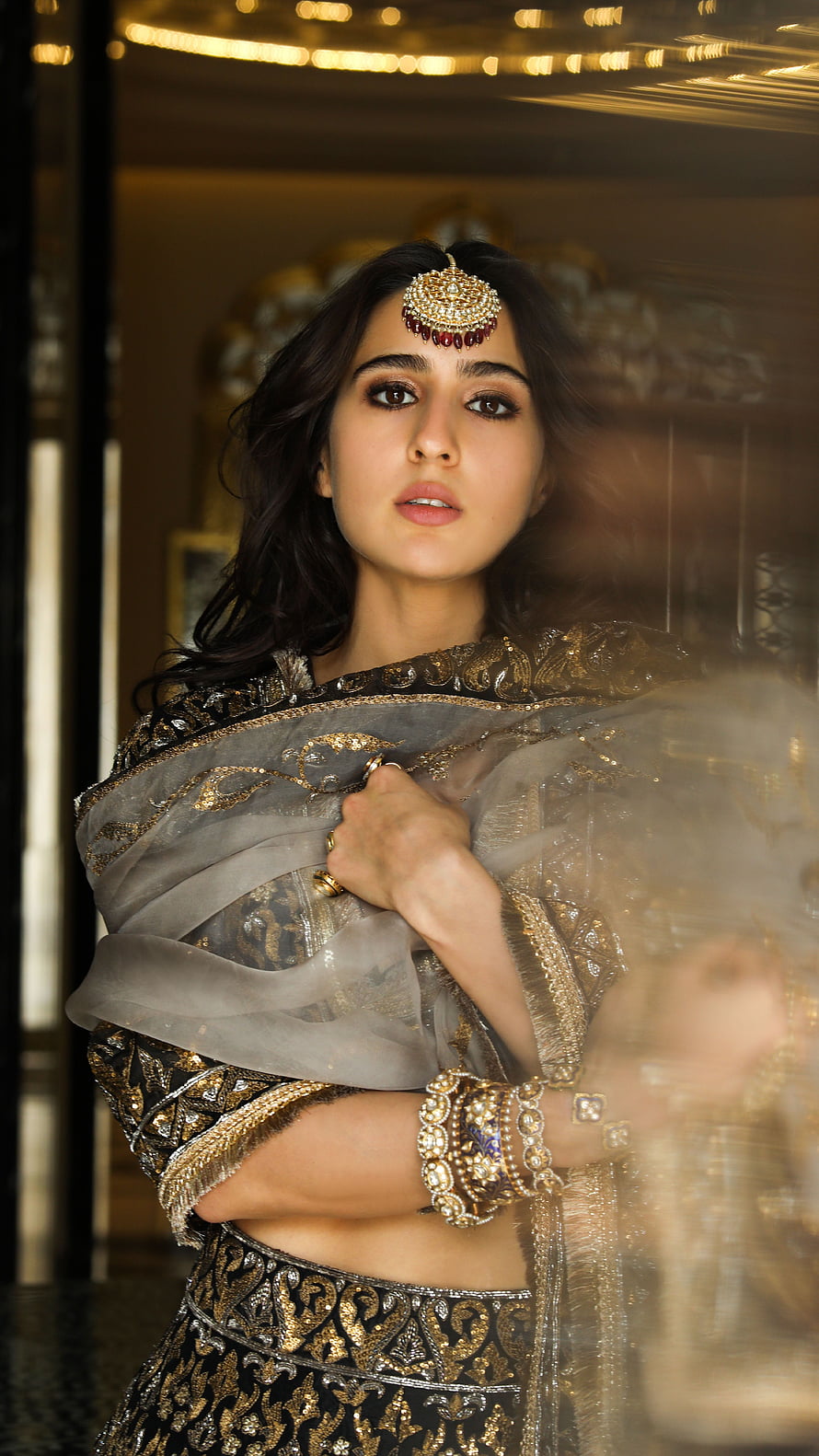 Sara Ali Khan in ornate black and gold lehenga with traditional maang tikka and heavy jewelry HD phone wallpaper