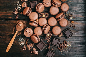 Rustic Flat Lay of Chocolate Macarons and Dark Chocolate Squares on Weathered Wood HD wallpaper
