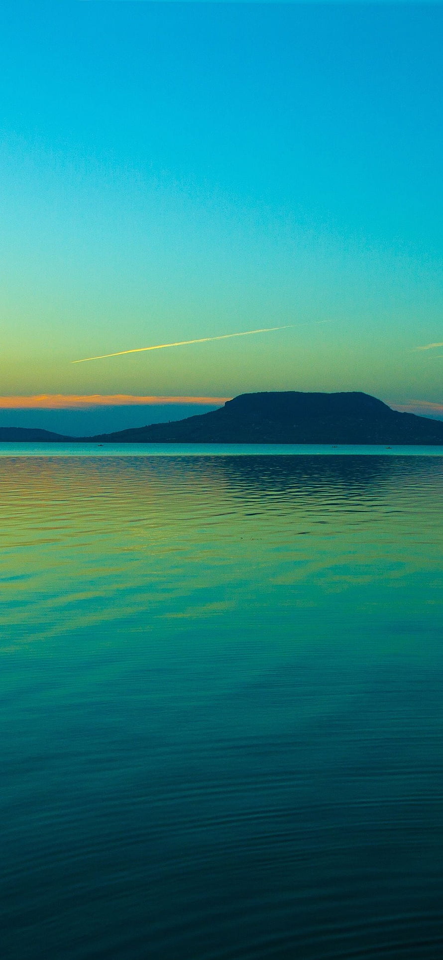 Tranquil Coastal Horizon at Dusk with Distant Island Silhouette and Calm Turquoise Waters HD phone wallpaper