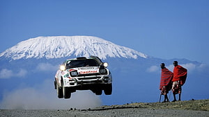 Toyota Celica WRC Rally Car Airborne Over Maasai Warriors With Snow-Capped Kilimanjaro HD wallpaper