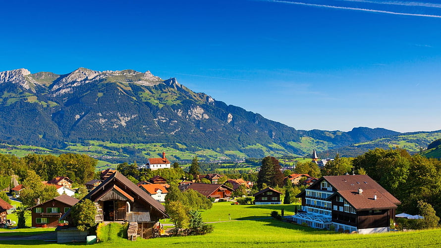 Alpine Village in Switzerland with Chalets and Mountain Backdrop HD wallpaper