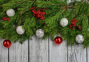 Festive Christmas Garland With Pine Branches, Red Berries, and Silver Ornaments on White Wood HD wallpaper