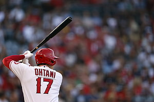 Shohei Ohtani in Angels uniform holding bat at home plate during a baseball game HD wallpaper