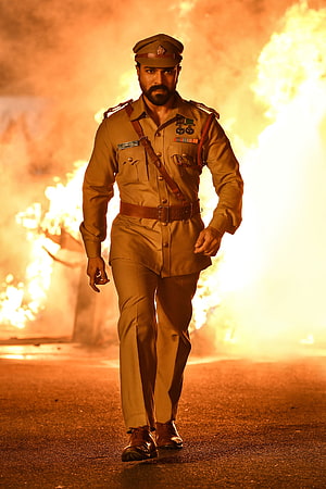 Ram Charan in RRR military uniform walking through flames HD phone wallpaper