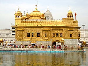 Harmandir Sahib Golden Temple in Amritsar with pilgrims gathered at the sacred water tank HD wallpaper